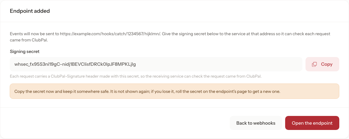 The Endpoint added card naming the example.com address events will now be sent to, the signing secret starting whsec_ with a Copy button, a warning that the secret is not shown again, and the Back to webhooks and Open the endpoint buttons